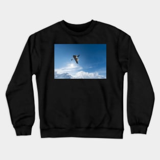 Snowboarder jumping against blue sky Crewneck Sweatshirt